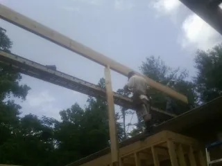 Carpenter setting a ridge beam over a new addition frame — Ice Dam Removal by Roofing Brothers in Vardaman