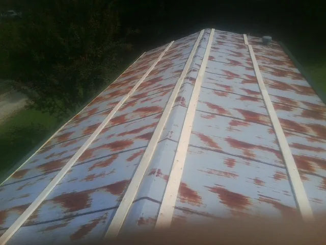 Rusted metal roof panels with new wood purlins before replacement — Storm Damage Roof Repair in Vardaman by Roofing Brothers