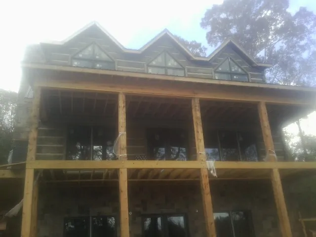 Dormers and porch framing on a large log home under construction — Roof Coating work by our crew in Vardaman