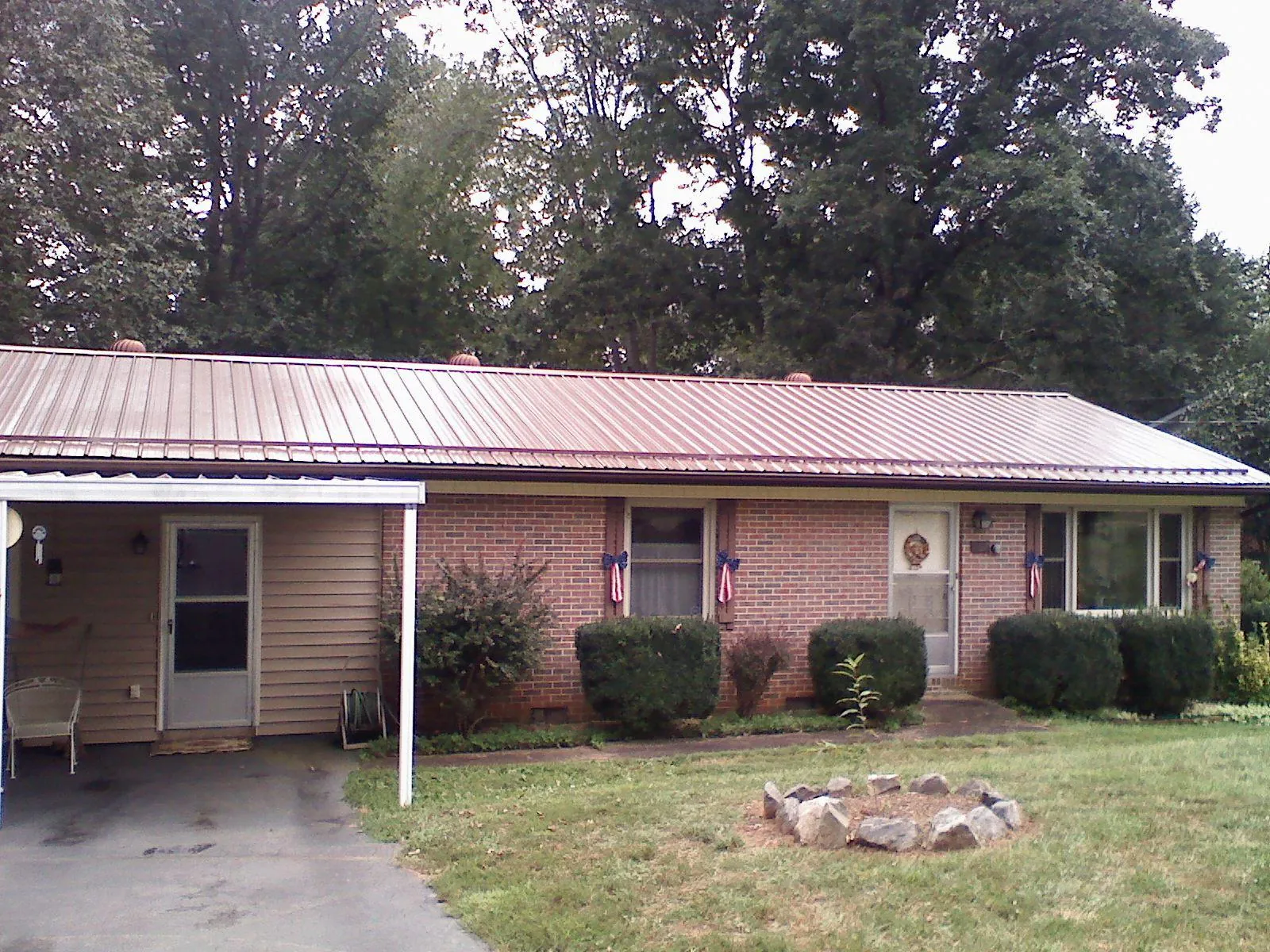 Bronze metal roof and carport on a brick ranch home — Roof Repair work by our crew in Vardaman